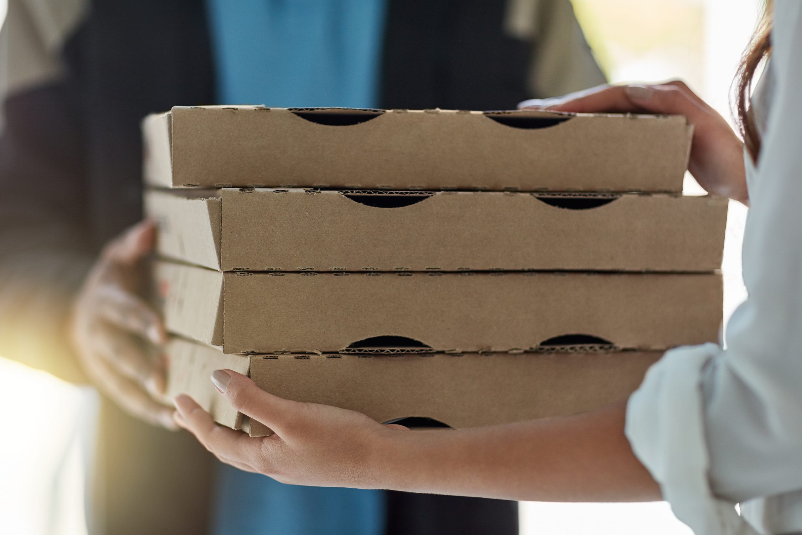 Cropped shot of a man making a pizza delivery to a customer.